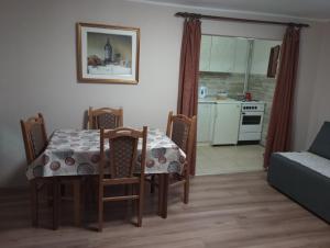una sala da pranzo con tavolo e sedie e una cucina di Apartmani Dunav Apatin a Apatin