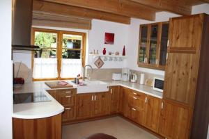 una cucina con armadi in legno e piano di lavoro bianco di Ferienhaus-am-Kuhmoor a Wismar