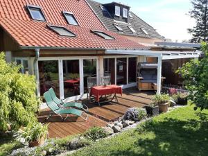 una casa con terrazza arredata con tavolo e sedie di Ferienhaus-am-Kuhmoor a Wismar