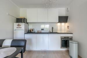 a small kitchen with white cabinets and a table at *Disneyland-Paris*4pers,Wifi, Netflix, parking in Chessy