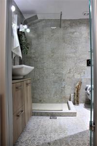 a bathroom with a shower with a sink and a toilet at Théa Apartment in Rethymno Town +24 photos