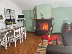 - un salon avec une table et une cheminée dans l'établissement Villa con bosco giardino e ruscello ad uso esclusivo, à Borzonasca
