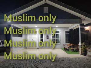 a house at night with the words muslin only muslinimi only muslin at Se SE d'Homestay Kelulut Marang in Marang