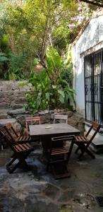 stół piknikowy i dwa krzesła siedzące obok ściany w obiekcie Lo de Leo w mieście Salta