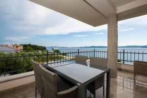 a table and chairs on a balcony with a view of the water at Lila1 Apartments in Zadar