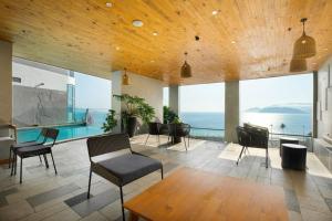 sala de estar con piscina, mesa y sillas en MySea Panorama Nha Trang Superview Apartments en Nha Trang