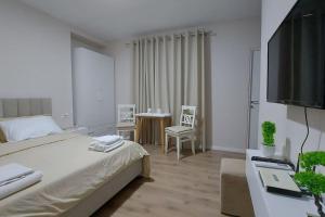 a bedroom with a bed and a desk with a television at Tranquil Oasis for Two in Tirana