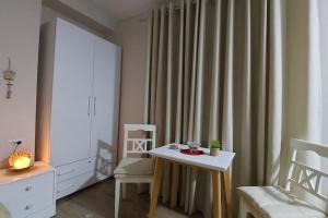 Zimmer mit einem Tisch, Stühlen und einem Vorhang in der Unterkunft Tranquil Oasis for Two in Tirana