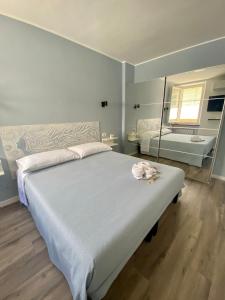 een slaapkamer met een groot bed en een spiegel bij ReMare in Porto Recanati