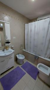 a bathroom with a sink and a toilet and a shower at Tranquil Oasis for Two in Tirana