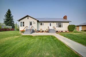 a white house with a patio and grass at Cozy Montana Retreat with Patio, Grill and Fire Pit! in Choteau