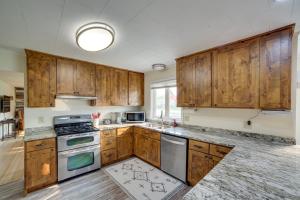 a kitchen with wooden cabinets and stainless steel appliances at Cozy Montana Retreat with Patio, Grill and Fire Pit! in Choteau