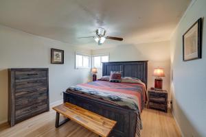 a bedroom with a bed and a ceiling fan at Cozy Montana Retreat with Patio, Grill and Fire Pit! in Choteau