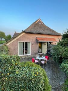 een huis met een patio met een tafel en stoelen bij An de Esch in Dwingeloo