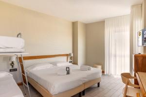 ソットマリーナにあるB&B Hotel Chioggia Aironeのベッドとデスクが備わるホテルルームです。