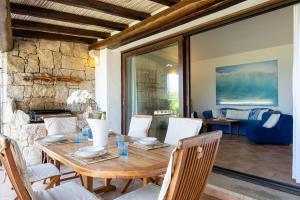 a dining room with a wooden table and chairs at [VILLETTA VISTA MARE] Cala dei Ginepri con Giardino in Cala Bitta
