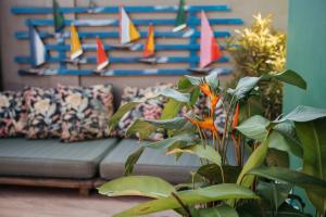 Casa Buziana - Lofts amplos e super equipados في بوزيوس: أريكة في غرفة معيشة مع نبات