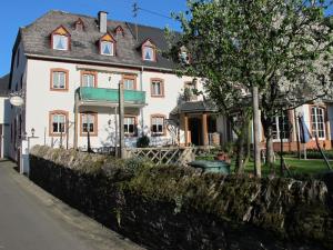Biały dom z drzewem przed nim w obiekcie Weinhof Michael Morbach w mieście Zeltingen-Rachtig