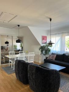 sala de estar con sofá y mesa en Rymlig och modern lägenhet i villa. Perfekt för familjer. Med parkering. en Malmö