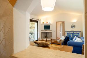 a living room with a blue couch and a fireplace at [VILLETTA VISTA MARE] Cala dei Ginepri con Giardino in Cala Bitta