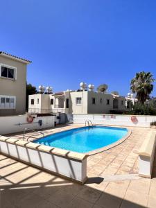 a swimming pool in front of a house at Sirena Kings in Paphos