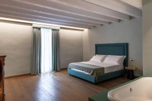 a bedroom with a bed and a tub in a room at Palazzo De Gregorio Apartments in Palermo