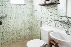 a bathroom with a toilet and a sink at Casa Buziana - Lofts amplos e super equipados in Búzios