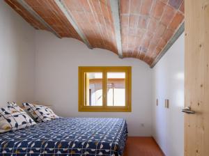 a bedroom with a bed with a blue comforter at Ca la Carolina in Rabós