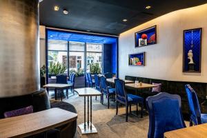 - un restaurant avec des tables et des chaises bleues dans une pièce dans l'établissement Hôtel Diva Opera, à Paris