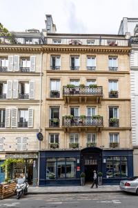 un edificio en una calle con gente caminando delante de él en Hôtel Diva Opera, en París