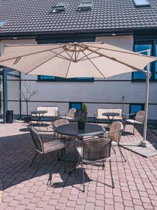 patio ze stołami, krzesłami i parasolem w obiekcie Agroturystyka u Maryli w Stroniu Śląskim