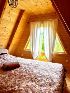 sypialnia z łóżkiem i oknem w kabinie w obiekcie Etno house Bajka w mieście Žabljak