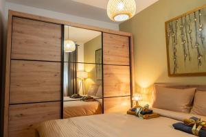 ein Schlafzimmer mit einem großen Spiegel und einem Bett in der Unterkunft Apartman Nest in Vranje