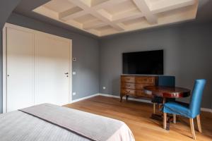 a bedroom with a bed and a desk and a television at Palazzo De Gregorio Apartments in Palermo