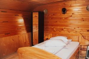 a bedroom with a bed in a wooden room at Cabana Bombonel in Gura Teghii +62 photos