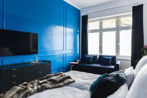 um quarto azul com uma cama, uma televisão e uma cadeira em 165m2 Downtown Family Suite 5BR, 3Bath, kids room, 11min Alexanderplatz em Berlim