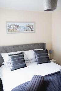 a bedroom with a bed with black pillows at Vanity Ballycastle Diamond 2 bedroom apartment in Ballycastle