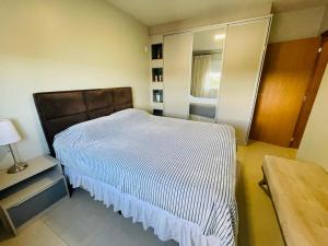 1 dormitorio con cama, espejo y mesa en Próx Lago Municipal, com vaga de garagem, en Toledo