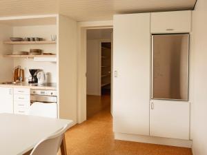 uma cozinha com armários brancos e um frigorífico em 2BR apartment / Tórshavn / 10min walk to city centre em Tórshavn