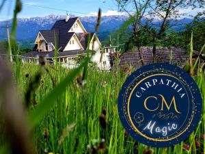 een bord in het gras voor een huis bij Carpathia Magic -adults only in Peştera +54 foto's