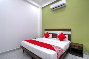 - une chambre avec un lit et des oreillers rouges dans l'établissement OYO 71370 White House, à Garhi Harsāru