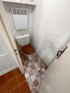 La salle de bains est pourvue de toilettes et d'un siège en bois. dans l'établissement Fisherman House by iCasamia, à Antibes