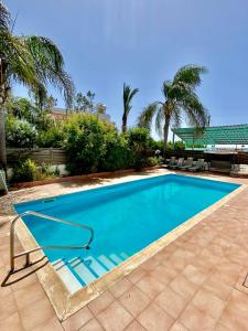 a swimming pool in a yard with palm trees at Sea View Villa in Agia Thekla in Ayia Napa