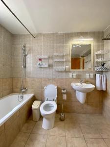 a bathroom with a toilet and a tub and a sink at Sea View Villa in Agia Thekla in Ayia Napa