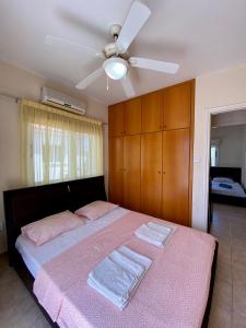 a bedroom with a bed with a ceiling fan at Sea View Villa in Agia Thekla in Ayia Napa