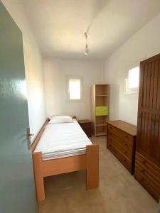 1 dormitorio con 1 cama y armario de madera en Zefiria Countryside Cottage en Zefiría
