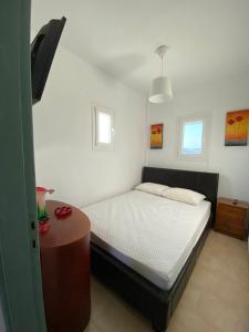 a small bedroom with a bed and a table at Zefiria Countryside Cottage in Zefiría