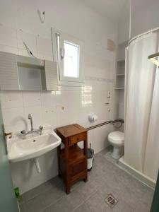 biała łazienka z umywalką i toaletą w obiekcie Zefiria Countryside Cottage w mieście Zefiría