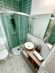 a bathroom with a shower and a toilet and a sink at GATU PREMIUM ático Caleta in Cádiz