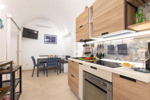 a kitchen with wooden cabinets and a dining room at Coral - 30 passi dalla Spiaggia della Purità in Gallipoli
